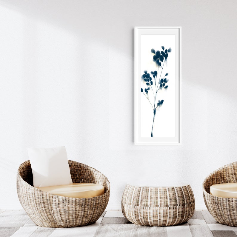 Peut inclure: Deux chaises en osier avec coussins et une table en osier devant un mur blanc avec une estampe encadr&eacute;e en noir et blanc d'une plante stylis&eacute;e.