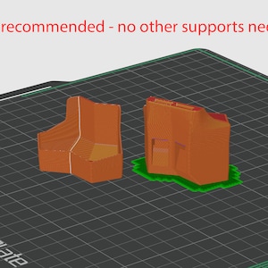 May include: Two 3D printed objects, one with a rectangular shape and the other with a more complex shape, are shown on a black and green grid surface. The text "Raft recommended - no other supports needed" is displayed above the objects.