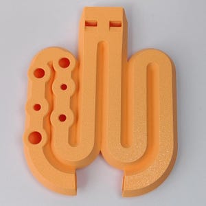 Puede incluir: Escultura abstracta de color naranja con superficie texturizada. El diseño presenta una serie de formas conectadas, incluyendo un elemento rectangular vertical con dos ranuras horizontales y una estructura similar a una cadena con agujeros circulares. La obra está sobre fondo blanco.