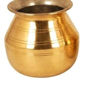 May include: A polished brass pot with a rounded body and a wide, flared rim. The exterior features three horizontal engraved lines circling the midsection. Below the pot, a small rectangular brass plaque displays the text 1 Litre.