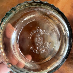 May include: A clear glass baking dish with a scalloped rim. The bottom of the dish has the text "Ovenproof" and "Made in USA" with an anchor logo.