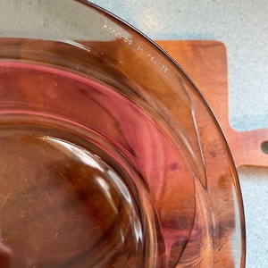 May include: A clear glass baking dish with a brown tint. The dish has the words "MADE IN FRANCE" printed on the bottom.