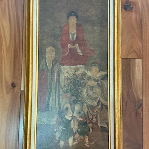 Peut inclure: Une peinture rectangulaire encadrée représentant une figure centrale en robe rouge assise au-dessus, flanquée de deux personnages debout en robes superposées, avec trois petites figures au premier plan près d'une plante, dans un cadre doré.