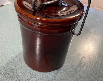 Jarra de cerámica vintage: Tarro de cerámica con esmalte marrón y alambre para colgar.