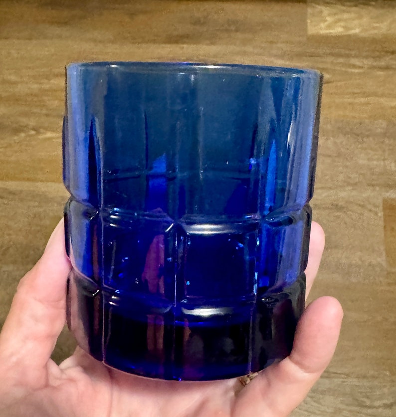 May include: A cobalt blue glass tumbler with a square patterned design.