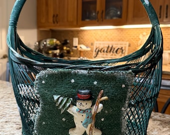 Stary wiklinowy koszyk świąteczny w kształcie bałwana w kolorze zielonym z ozdobnymi detalami z juty