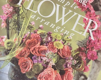 May include: A magazine cover featuring a floral arrangement in a clear glass vase. The magazine is titled "Southern Living simple FLOWER arranging".