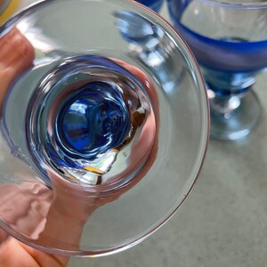 K&ouml;nnte beinhalten: Ein klares Glas mit einem blau-wei&szlig; gestreiften Design. Das Glas wird auf den Kopf gestellt, wodurch das Innere des Glases sichtbar wird.