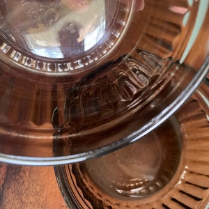 May include: Two clear glass bowls with a brown tint and a fluted edge. The bowls are nested together.