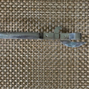 以下が含まれることがあります： 黒いハンドルが付いた銀色の缶切りで、"25c"と"TRADE MARK"の文字が印刷されています。