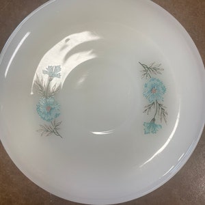 Puede incluir: Taz&oacute;n de cer&aacute;mica blanco con un dise&ntilde;o floral con flores azules y verdes. El taz&oacute;n es perfecto para servir aperitivos o postres.