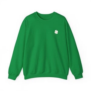 May include: A bright green sweatshirt with a small white four-leaf clover embroidered on the left chest. The long-sleeved crew neck top is made of a soft material and is suitable for casual wear. The design is simple and festive.