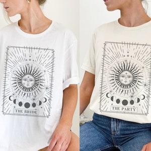May include: Two white t-shirts with a black and white graphic print of a sun and moon with the text "The Bride" and "The Party".