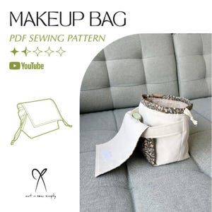 May include: A cream-colored makeup bag with a floral patterned interior and a white flap secured with Velcro. The bag has a drawstring closure and is displayed on a gray sofa. Text on the image reads "MAKEUP BAG PDF SEWING PATTERN".
