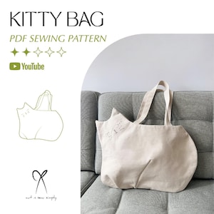 Może przedstawiać: Beżowa płócienna torba typu tote z motywem kota. Torba ma wyszytą twarz kota z przodu i długie uchwyty. Tekst "KITTY BAG" i "PDF SEWING PATTERN" znajdują się na górze. Widoczne jest również logo YouTube.