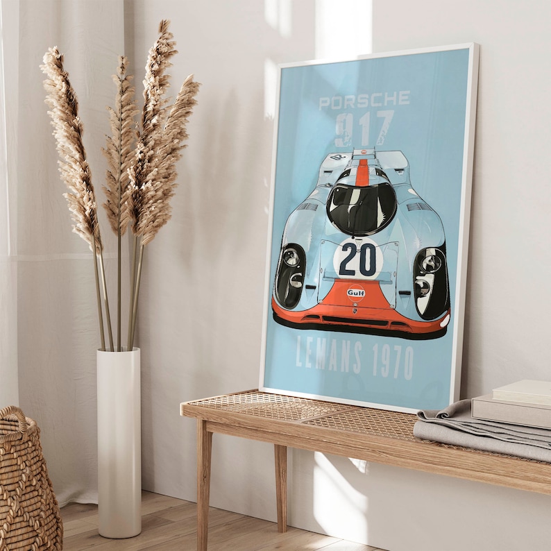 May include: A blue and white poster with a vintage race car illustration. The car is a Porsche 917 with the number 20 and the word "Gulf" on it. The poster says "Porsche 917 Le Mans 1970".