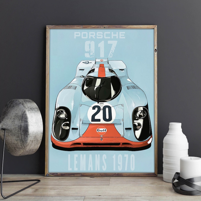 May include: A blue and orange vintage poster featuring a white Porsche 917 race car with the number 20 and the word "Gulf" on the front. The poster has the text "Porsche 917 Le Mans 1970" at the bottom.