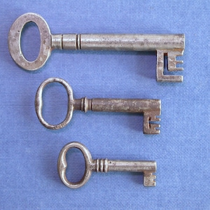 May include: Three antique keys with ornate metal handles and intricate designs on the shafts. The keys are arranged vertically on a blue background.