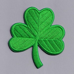 以下が含まれることがあります： キルティングのデザインが施された緑色のフェルト製のクローバーパッチ。