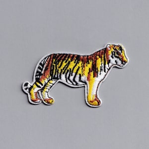 May include: Embroidered iron-on patch of a yellow, orange, and black tiger standing on a white background.