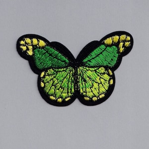 May include: Green and yellow embroidered butterfly patch with black outline.