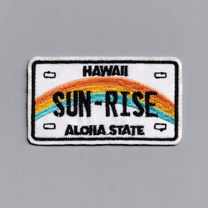 Könnte beinhalten: Weißer gestickter Aufnäher mit einem Regenbogenmuster und dem Text "HAWAII SUN-RISE ALOHA STATE".