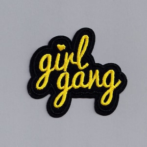 May include: Yellow embroidered patch with the words "girl gang" on a black background.