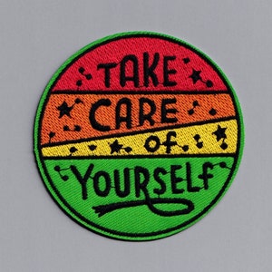 May include: A round, green, yellow, orange, and red embroidered patch with the text "TAKE CARE of YOURSELF" in black.