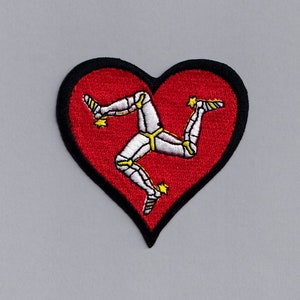 May include: A red heart-shaped patch with a white embroidered three-legged symbol, known as the 'Three Legs of Man', on a black background.
