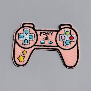 May include: A pink embroidered patch of a video game controller with the word "FONY" written on it. The controller has a black outline and yellow stars on the left side.