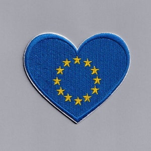 May include: A blue heart-shaped patch with a circle of 12 yellow stars in the centre. The patch is a representation of the European Union flag.