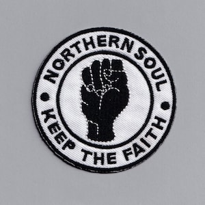 Peut inclure: Patch brodé noir et blanc avec un poing levé et le texte "Northern Soul Keep The Faith".