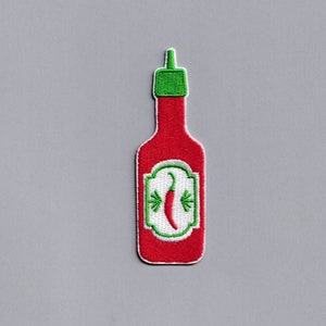 May include: Embroidered patch of a red hot sauce bottle with a green cap. The label features a red chili pepper and green accents. The patch is on a gray background.