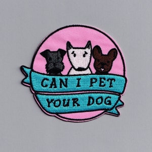 Może przedstawiać: Naszywka haftowana w kolorze różowym i niebieskim z trzema kreskówkowymi psami i tekstem "Can I Pet Your Dog?"
