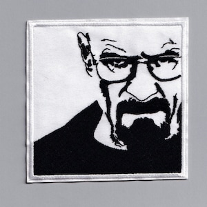 May include: Black and white embroidered patch of a man's face with glasses and a beard. The patch is on a white background.
