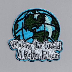 Könnte beinhalten: Ein gestickter Aufnäher in Blau und Grün mit einem Cartoon-Bild der Erde und dem Text "Making the World a Better Place".