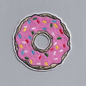Puede incluir: Parche bordado de donut rosa con chispas de colores.
