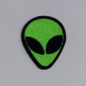 Puede incluir: Parche bordado de cabeza de extraterrestre verde con ojos negros.