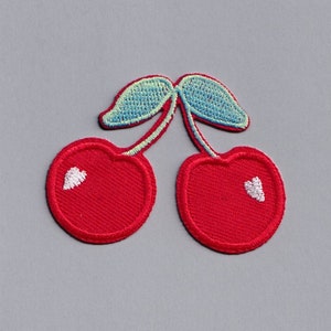 May include: A red embroidered cherry patch with green leaves.