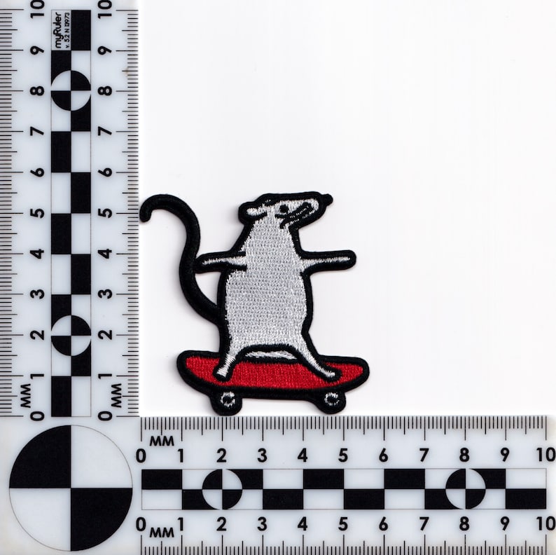 May include: Embroidered patch featuring a gray rat skateboarding on a red skateboard. The rat has black outlines and a long, curved tail. The patch is designed with a playful, cartoonish style, suitable for clothing or accessories.