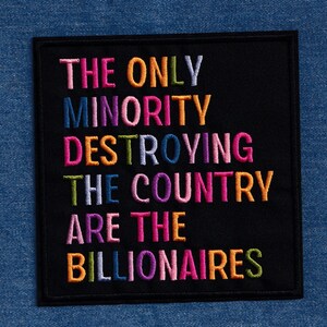 Pu&ograve; includere: Toppa ricamata nera con la scritta "THE ONLY MINORITY DESTROYING THE COUNTRY ARE THE BILLIONAIRES" in vari colori. La toppa &egrave; quadrata e ha un bordo nero. Lo sfondo &egrave; in denim blu.
