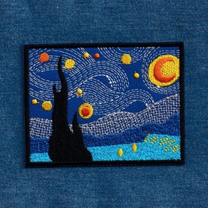 May include: Embroidered patch featuring a starry night scene with a crescent moon, swirling clouds, and a tall, dark tree. The patch is on a blue denim background.