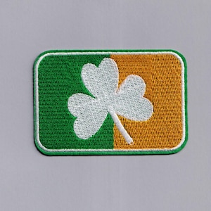 May include: A green and gold embroidered patch with a white shamrock.