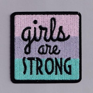 Peut inclure: Écusson brodé avec les mots "girls are STRONG" en écriture noire et en lettres majuscules. Le patch a une bordure noire et présente un dégradé de couleurs rose, lavande et turquoise.