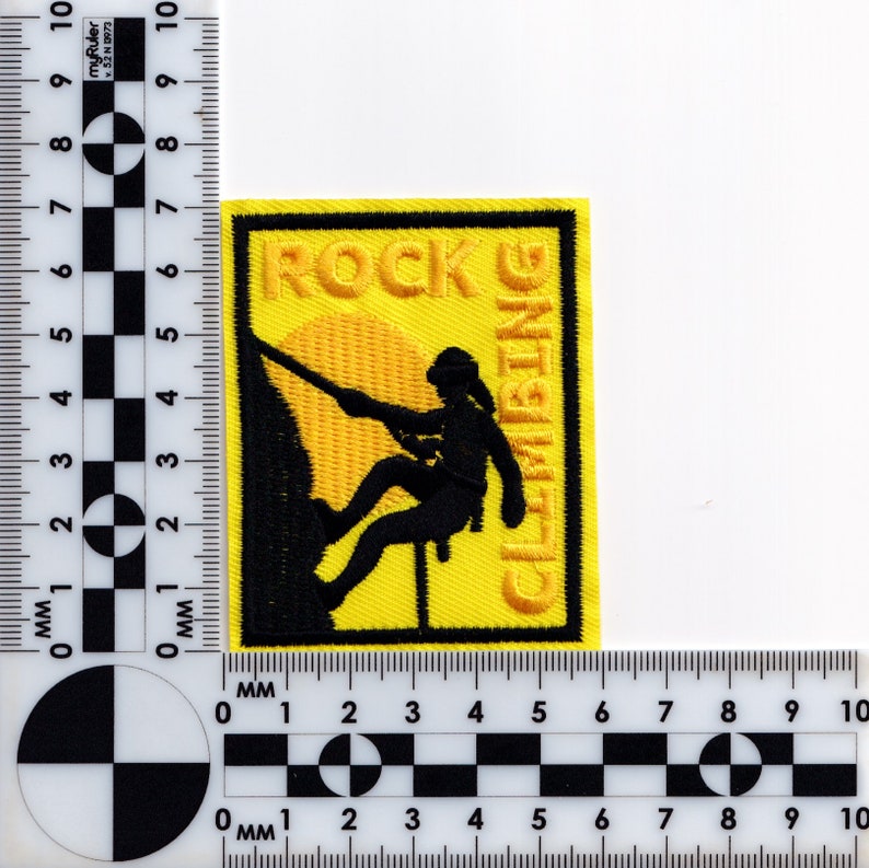 May include: Yellow embroidered patch with black stitching. The patch features a silhouette of a person rock climbing with the words "ROCK CLIMBING" in yellow.
