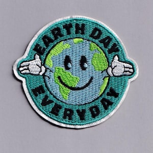 May include: Embroidered patch with a smiling Earth graphic, green continents, and the text "Earth Day Everyday" in black. The patch has a teal border and white hands extending from the globe.