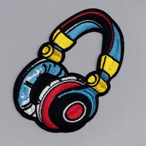 Op de afbeelding: Een kleurrijk geborduurd patch van een koptelefoon met blauwe, gele, rode en witte accenten.