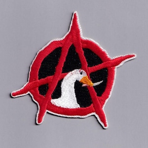 May include: Embroidered patch with a white goose and orange beak within a black circle, crossed by a red anarchy symbol. The patch has a white border, set against a grey background.