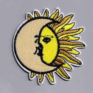 May include: Embroidered patch with a celestial design of a smiling sun and moon. The sun's rays are yellow and gold, while the moon is a light tan colour. The patch has a white border and is likely for clothing or accessories.
