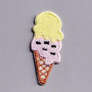 Puede incluir: Parche bordado de cono de helado. El helado tiene una parte superior amarilla, una parte media rosa con detalles negros y una base de cono de gofre marrón. Este parche es adecuado para ropa o accesorios. Los colores son amarillo, rosa y marrón.